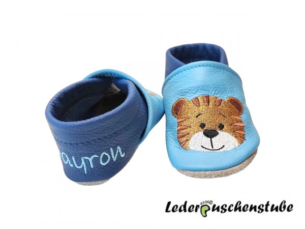 Lederpuschen hellblau-jeansblau mit beiderseits Stickerei Tigergesicht ocker-rotbraun-creme-schwarz und beiderseits Ferse den Namen hellblau